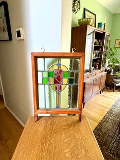 a small stained glass window sitting on top of a wooden table in a living room