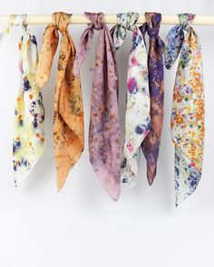 several different colored ties hanging from a clothes line