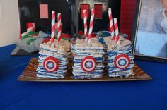 captain america cupcakes with candy sticks in them on a plate next to a framed photo