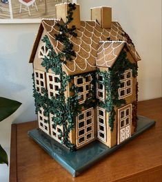 a gingerbread house with ivy growing on the roof