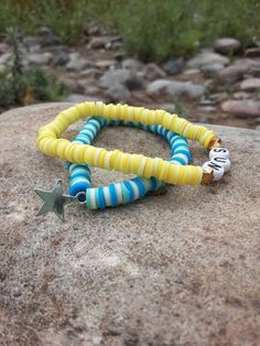 Summer may have ended, but we can keep the spirit alive with these bright, cheerful, and summery bracelets! ☀️ Picture yourself strolling along the beach, sipping on a cool drink, and flaunting these bracelets that scream summertime joy. 🏖️ Starstruck in Blue: One bracelet in this dynamic duo boasts a dazzling ocean blue hue, a true homage to those clear summer skies. Adorned with a twinkling star charm, it's your very own piece of the night sky right at your wrist. Whether you're a dreamer or just love a little celestial bling, this one's for you! 🌟 Here Comes the Sun: The second bracelet is a cheerful burst of sunshine itself! In radiant yellow, it practically screams sun! It's the perfect reminder to soak up these last rays and seize the day. Plus, you can wear these fabulous bracelet Beachy Summer Bracelets With Letter Beads, Beachy Beaded Bracelets For Friendship In Summer, Fun Colorful Beaded Friendship Bracelets For Vacation, Colorful Beaded Fun Friendship Bracelets For Vacation, Colorful Beads Friendship Bracelets For Vacation, Colorful Beaded Friendship Bracelets For Vacation, Fun Colorful Beaded Bracelets For The Beach, Beaded Bracelets For Beach Party In Summer, Beaded Bracelets For Summer Beach Party