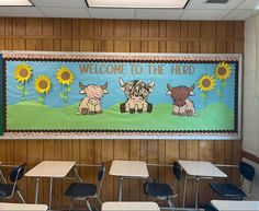 a classroom with desks, chairs and a welcome to the herd banner on the wall