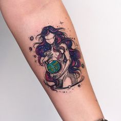 a woman with long hair holding a globe tattoo on her arm