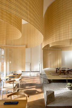 a room with tables, chairs and bamboo blinds on the ceiling is shown in this image