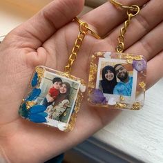 two people are holding small square pictures in their hands, one is wearing a gold chain and the other is wearing a blue shirt