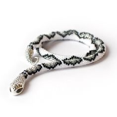 black and white beaded bracelet with silver clasps on a white background, close up