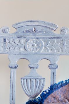 the headboard and foot board of a white bed with blue ruffled bedspread