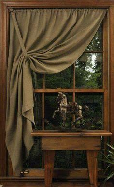 an image of a window with curtains and a dog looking out the window at it