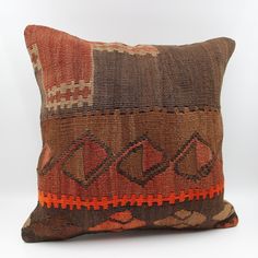 a brown and orange pillow sitting on top of a white floor