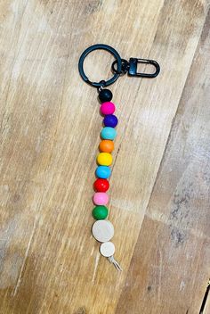 a keychain made out of buttons on top of a wooden table