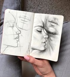 a woman's hand holding an open notebook with two drawings on the pages,