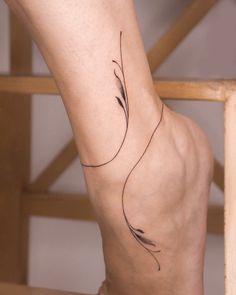 a woman's foot with a small tattoo on her left leg and the bottom part of her body