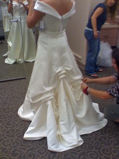 a woman in a white wedding dress getting ready