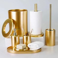 gold bathroom accessories including toiletries and soap dispensers on a white surface