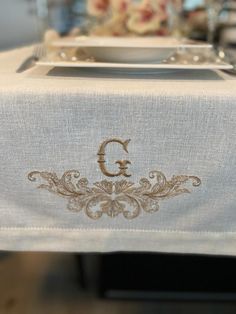 the monogrammed table cloth has been embroidered onto it