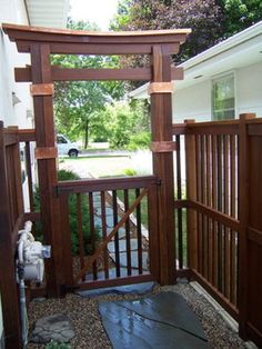 an open wooden gate in front of a house