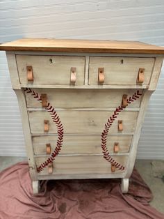 an old dresser with baseball stitches painted on it