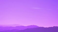 a purple sky with mountains in the background