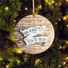 a wooden ornament hanging on a christmas tree that says oh what fun it is to read