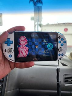 a person holding a game controller in their hand while sitting in a car with the steering wheel behind them