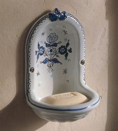 a blue and white ceramic soap dish hanging on a wall