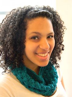 a woman with curly hair wearing a green scarf