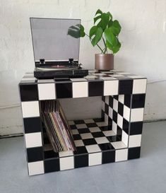 a record player sitting on top of a black and white checkerboard side table