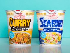 two yogurt cups sitting next to each other on a blue surface with the words curry written in japanese