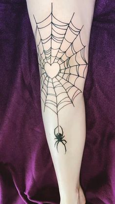 a woman's legs with a spider web tattoo on the bottom of her leg