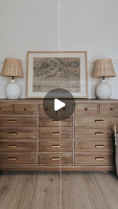 a dresser with two lamps on top of it and a basket in front of it