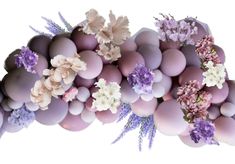 an arrangement of flowers and eggs are arranged in the shape of a bird's nest