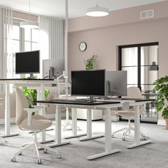 an office with two computer screens and chairs