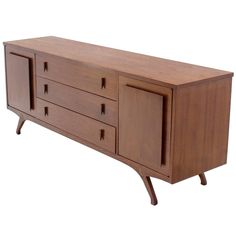 a wooden sideboard with three drawers on one end and two doors on the other