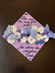 a purple graduation cap with butterflies on it that says, this is the very first page