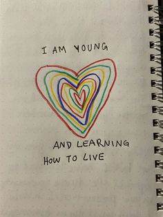 i am young and learning how to live written on a spiral notebook with colored hearts