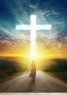 a woman walking down a road with a cross above her head in the sky at sunset