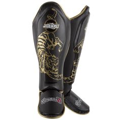 a pair of black and gold shinks with tiger design on the soles,