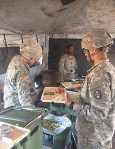 some soldiers are serving themselves food in a tent