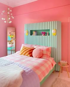 a bedroom with pink walls and striped bedspread on the bed is decorated in pastel colors