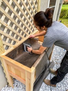 a woman is sanding up a wooden bench