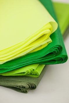 several folded papers are stacked on top of each other in bright green and yellow colors