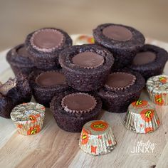 chocolate cupcakes on a plate with candy wrappers