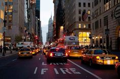 the city street is crowded with cars and people