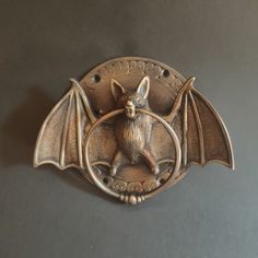 a bat shaped metal object on a gray surface