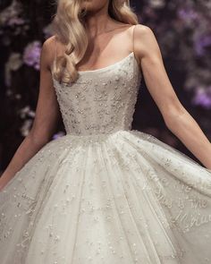 a woman in a wedding dress walking down the runway with her hand on her hip