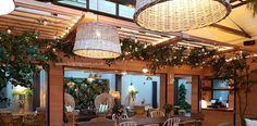 an indoor dining area with wicker furniture and hanging plants