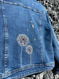 a blue jean jacket with dandelions on it