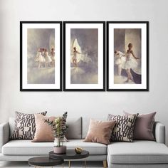 three framed paintings on the wall above a couch