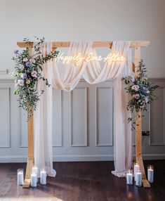 a wedding arch decorated with flowers and candles