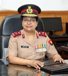 a woman in uniform sitting at a desk with a book on it's lap